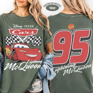 Może przedstawiać: Zielona koszulka z Lightning McQueen z filmu Auta Disneya Pixara. Prz&oacute;d przedstawia logo Auta, szachownicę i Lightning McQueen. Tył ma duży numer 95 i napis "Lightning McQueen".