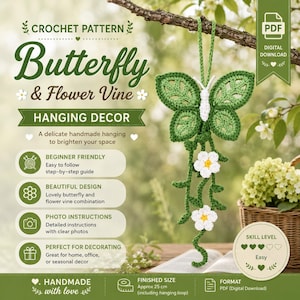 May include: A digital PDF crochet pattern for a butterfly and flower vine hanging decor. The pattern features a green crocheted butterfly with a white body and two white flowers on a vine. The finished size is approximately 25 cm in length.