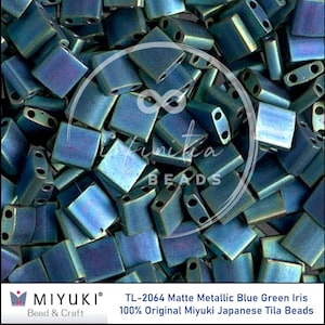 May include: A collection of matte metallic blue-green iris Tila beads. These square-shaped beads have two holes for stringing. The image includes the text "INFINITICA BEADS" and "MIYUKI Bead & Craft".