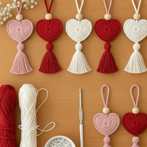 May include: Crocheted heart-shaped ornaments in pink, red, and white with matching tassels and wooden beads. The image also shows yarn, a crochet hook, and a bowl of beads, suggesting a handmade craft project.