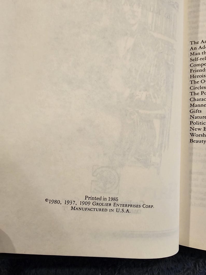 May include: Open book page with text and a logo. The text reads "Printed in 1985" and "&copy;1980, 1937, 1909 GROLIER ENTERPRISES CORP. MANUFACTURED IN U.S.A." The page is off-white with a faded illustration in the background.