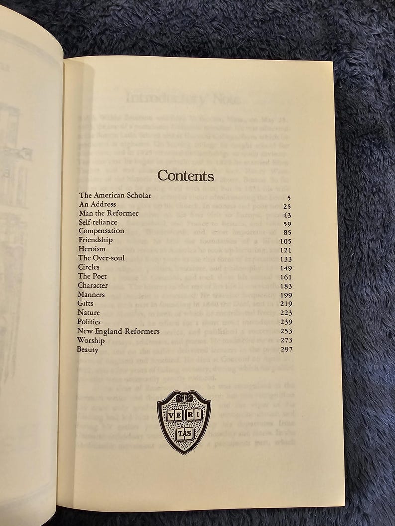 May include: Open book page with the title "Contents" and a list of chapter titles, including "The American Scholar" and "Man the Reformer." A small emblem is at the bottom of the page.