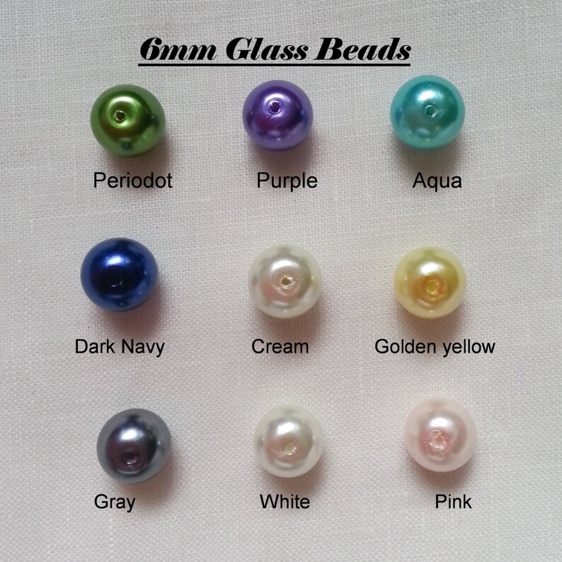 Puede incluir: Surtido de cuentas de vidrio de 6 mm en varios colores, incluyendo verde peridoto, morado, aguamarina, azul marino oscuro, crema, amarillo dorado, gris, blanco y rosa.