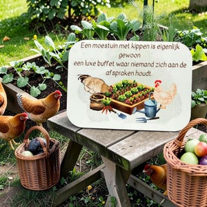 Op de afbeelding: Een rechthoekig bord met afgeronde hoeken voorzien van een moestuinillustratie, twee kippen en de tekst: 'Een moestuin met kippen is eigenlijk gewoon een luxe buffet waar niemand zich aan de afspraken houdt.' Het bord staat op een houten bankje.