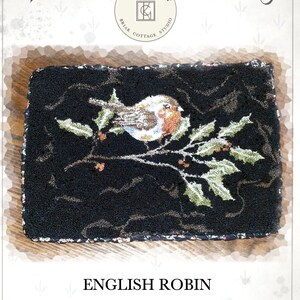May include: Punch needle pattern for an English Robin on a holly branch. The pattern is on black fabric with green holly leaves and red berries. The pattern is titled "English Robin" and is designed by Kate Gillery.