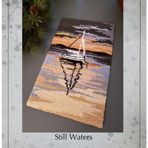 Peut inclure: Modèle de point d'aiguille pour un tapis représentant un voilier sur un lac au coucher du soleil. Le motif s'appelle "Still Waters" et est conçu par Kate Gillery. Le motif mesure 24,1 cm de haut sur 15,2 cm de large.