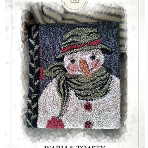 Pode incluir: Padrão de agulha de punção para um boneco de neve com um chapéu e uma echarpe verdes, com as palavras "Warm & Toasty" e "Design by Kate Gillery" abaixo da imagem.