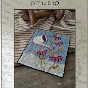 Peut inclure: Modèle de point d'aiguille pour un motif floral avec un arrosoir et le texte "Brings May Flowers". Le modèle est de Briar Cottage Studio et mesure 16 cm sur 13 cm.