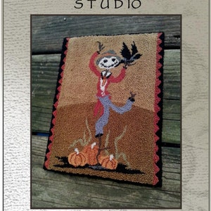 Puede incluir: Un diseño rectangular de aguja mágica titulado "Scare de Crow" de Briar Cottage Studio. El diseño presenta un espantapájaros con un cuervo, calabazas y el texto "Scare de Crow". El diseño mide aproximadamente 21 x 15 cm.