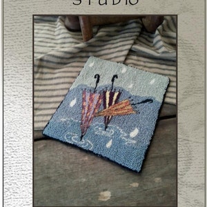 Peut inclure: Un modèle de point d'aiguille ou de broderie pour un projet de crochet de tapis appelé "April Showers". Le motif représente trois parapluies avec des gouttes de pluie tombant du ciel. Le motif mesure 16,5 cm sur 14 cm et est conçu par Kate Gillery.