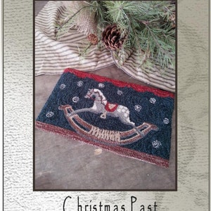 Peut inclure: Un modèle de point d'aiguille ou de broderie pour un motif de Noël passé représentant un cheval à bascule sur un fond bleu avec des flocons de neige blancs. Le motif mesure 23 cm sur 15 cm et est conçu par Kate Gillery.