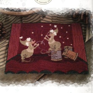 Peut inclure: Modèle de point de tapisserie pour un tapis de Noël représentant deux souris portant des bonnets de Père Noël et tenant des guirlandes lumineuses. Le tapis est rouge avec des flocons de neige blancs et une bordure vert foncé. Le motif est intitulé "Little Helpers" et est conçu par Kate Gillery.