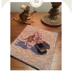 May include: A punch needle pattern featuring a mouse wearing a hat. The pattern is called "A New Hat" and is a punch needle pattern.