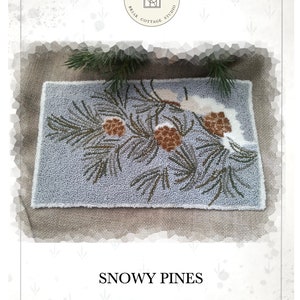 Peut inclure: Un motif de point de broderie représentant une branche de pin enneigée avec trois pommes de pin. Le motif est intitulé "Snowy Pines" et est conçu par Kate Gillery.