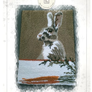 May include: Punch needle pattern for a bunny rabbit with a carrot. The pattern is called "Bunny Hop" and is designed by Kate Gillery.