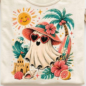 May include: A cream-colored t-shirt featuring a graphic of a ghost wearing a red sun hat and heart-shaped sunglasses. The design includes a yellow sun, a sandcastle, a seashell, a palm tree with a surfboard, and pink hibiscus flowers.