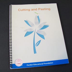 May include: A spiral-bound educational workbook titled Cutting and Pasting with a white cover featuring a stylized blue and white flower graphic. The bottom includes a blue horizontal band with the text Carden Educational Foundation.