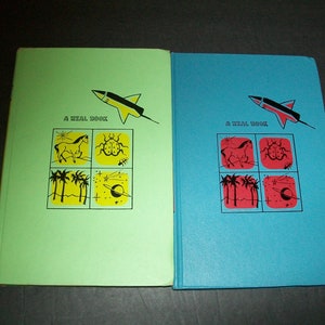May include: Two vintage children's books with green and blue covers. The covers feature a rocket ship, a horse, a ladybug, palm trees, a star, and a planet. The text on the covers reads "A Real Book".