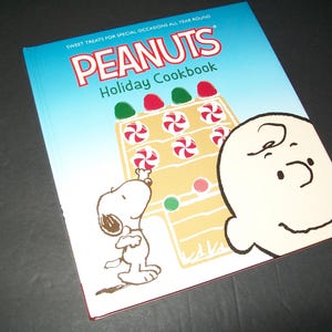 May include: A white ceramic mug with a black handle and the text "But First, Coffee" in a handwritten style. The mug is on a white surface. The mug is 4 inches tall.