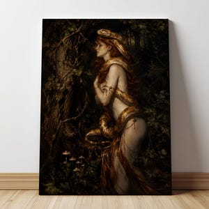 Könnte beinhalten: Ein rechteckiger Leinwanddruck mit einer dunklen, atmosphärischen Waldszene. Eine Figur mit langem rotem Haar ist von einer großen, gewundenen goldbraunen Schlange umhüllt. Die Figur trägt zarten goldenen Armschmuck und ein fließendes Gewand.