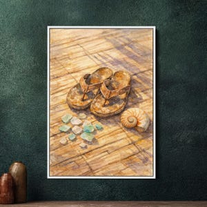 Könnte beinhalten: Aquarellmalerei von braunen Leder-Flip-Flops, einer Muschel und Meerglas auf einer Holzoberfläche. Das Kunstwerk hat eine warme, sonnige Farbpalette, die ein Strand- oder Küstenmotiv hervorruft. Die Flip-Flops sind abgenutzt.