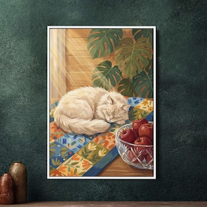 May include: A framed artwork depicts a fluffy, cream-colored cat sleeping peacefully on a colorful quilt. A glass bowl filled with red apples sits nearby. Large green leaves and wooden paneling are in the background.