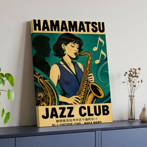 Könnte beinhalten: Ein rechteckiger Wandkunstdruck mit einer stilisierten Illustration einer Person, die Saxophon spielt. Der Text lautet HAMAMATSU JAZZ CLUB mit japanischen Schriftzeichen und der Adresse 91-1 CHITOSE-CHO - NAKA WARD in Schwarz auf blaugrünem Grund.