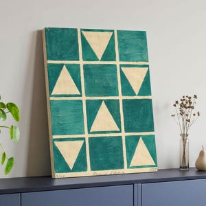 May include: A rectangular canvas print featuring a grid of twelve squares in a teal green hue. Each square contains either a solid teal block or a cream-colored triangle pointing upward or downward. The bottom edge displays the text 3/25 Epreuve d'Artiste.
