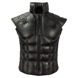 May include: A black sleeveless vest featuring a high collar and a padded, segmented torso design that mimics muscle definition. The garment includes a central vertical zip closure and decorative strap details on each shoulder area.