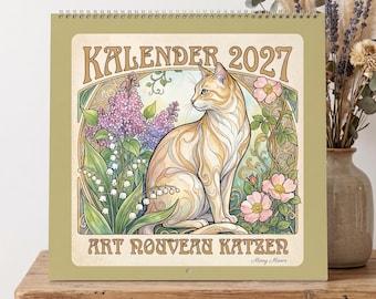 Peut inclure: Un calendrier mural carré intitulé KALENDER 2027 ART NOUVEAU KATZEN présentant une illustration centrale d'un chat orange clair entouré de lilas violets, de muguets blancs et de fleurs roses dans un cadre décoratif en arc.