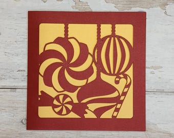 Tarjeta navideña con adorno de rayas de caramelo cortado con láser: Diseño artesanal rojo y dorado