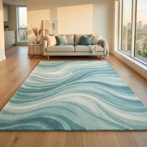 May include: A rectangular area rug featuring a flowing, wave-like pattern in various shades of teal, light blue, and white. The design consists of undulating, curved lines that create a sense of movement across the surface of the floor covering.