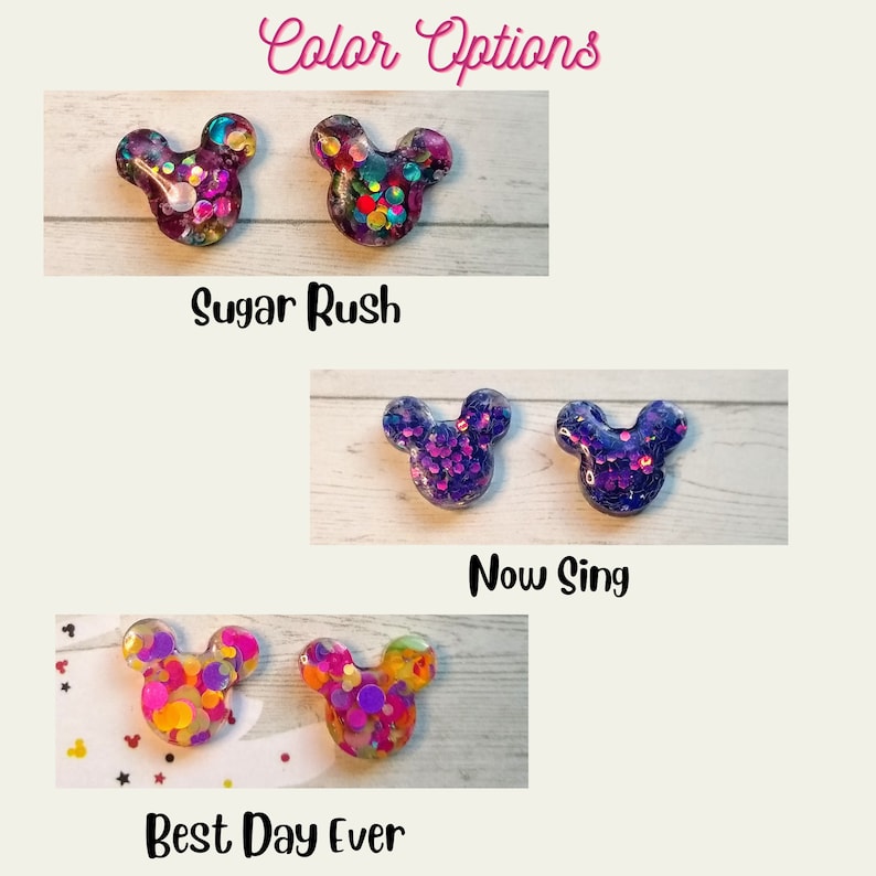 May include: Three pairs of colourful glitter Mickey Mouse earrings. The first pair is purple and pink with multi-coloured glitter. The second pair is purple with silver glitter. The third pair is yellow and orange with multi-coloured glitter. The text "Sugar Rush", "Now Sing", and "Best Day Ever" are below each pair of earrings.