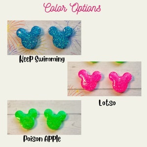 May include: Three pairs of glitter mouse ears in different colours: blue, pink, and green. The text "Keep Swimming", "Lotso", and "Poison Apple" are below each pair of ears.