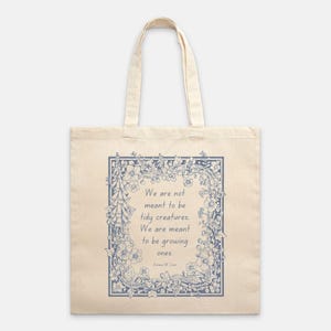 Puede incluir: Bolso tote de color crema con un dise&ntilde;o floral azul y la cita: "No estamos destinados a ser criaturas ordenadas. Estamos destinados a crecer". La bolsa tiene dos asas y est&aacute; hecha de una tela resistente.