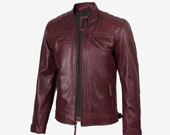 Puede incluir: Chaqueta de cuero burdeos con cuello alzado y cremallera frontal. La chaqueta tiene dos bolsillos en el pecho con cremallera y detalles acolchados en los hombros. Las mangas tienen puños con cremallera y una pequeña hebilla en la cintura. Estilo clásico.