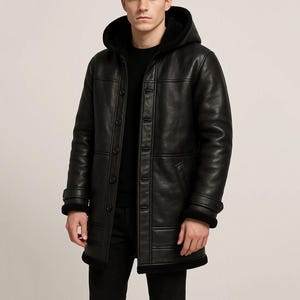 Peut inclure: Manteau à capuche en cuir noir avec fermeture boutonnée. Le manteau présente une doublure en fausse fourrure autour de la capuche et des poignets. Le manteau est long jusqu'aux genoux et a un design classique et ajusté.