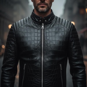 Op de afbeelding: Zwarte leren jas met een textuur die op krokodillenleer lijkt. De jas heeft een opstaande kraag, een zilveren ritssluiting en gewatteerde schouderdetails. De afbeelding is een medium shot, gericht op het bovenlichaam.