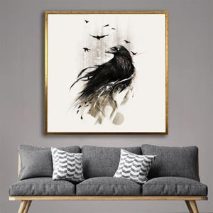 May include: A framed art print featuring a stylized black raven with white accents and a red line, set against a light background. Several smaller black birds are in flight above the raven. The artwork is in a gold frame.