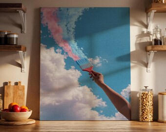 May include: A canvas print depicts a hand holding a paintbrush, seemingly painting a blue sky with pink and blue strokes. The artwork features fluffy white clouds and a red paintbrush handle. The overall theme is artistic and creative.
