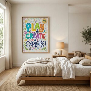 May include: A framed art print with the words "PLAY & CREATE & EXPLORE!" in colorful, whimsical lettering. The artwork features illustrations of rockets, stars, and a smiling sun, perfect for a child's bedroom or playroom.