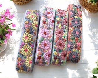 May include: Four rolls of floral embroidered trim in various colors, including pink, yellow, blue, and green. The trim is made of a sheer fabric with delicate floral embroidery.