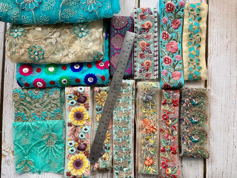 May include: Assortment of colorful embroidered trim with floral and geometric designs. The trim is made of a sheer fabric and is perfect for adding a touch of elegance to any project.