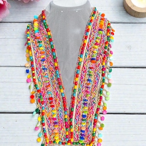 May include: A colorful beaded necklace with a V-neck design. The necklace features a variety of bright colors, including red, yellow, green, and blue. The necklace is displayed on a mannequin.