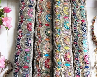 May include: Four strips of colorful trim with silver sequins and embroidery. The trim features a scalloped edge and a repeating pattern of half-circles.