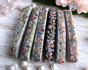 May include: A set of seven floral embroidered trims in various colors, including blue, pink, green, and black. The trims are made of a sheer fabric with a delicate floral pattern.
