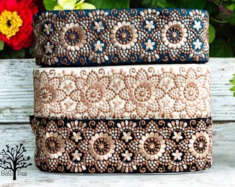 May include: Three rolls of decorative trim with intricate floral patterns. The trim is in shades of brown, white, and black.