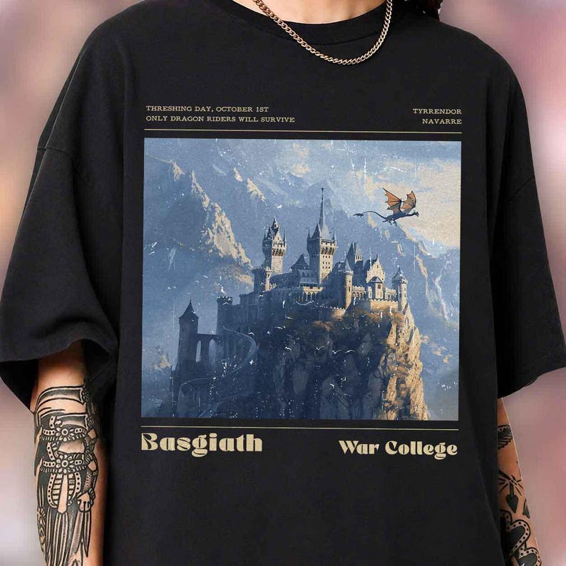 May include: Black t-shirt featuring a fantasy illustration of a castle atop a mountain, with a dragon flying nearby. Text includes "THRESHING DAY, OCTOBER 1ST", "ONLY DRAGON RIDERS WILL SURVIVE", "TYRRENDOR NAVARRE", "Basgiath War College".