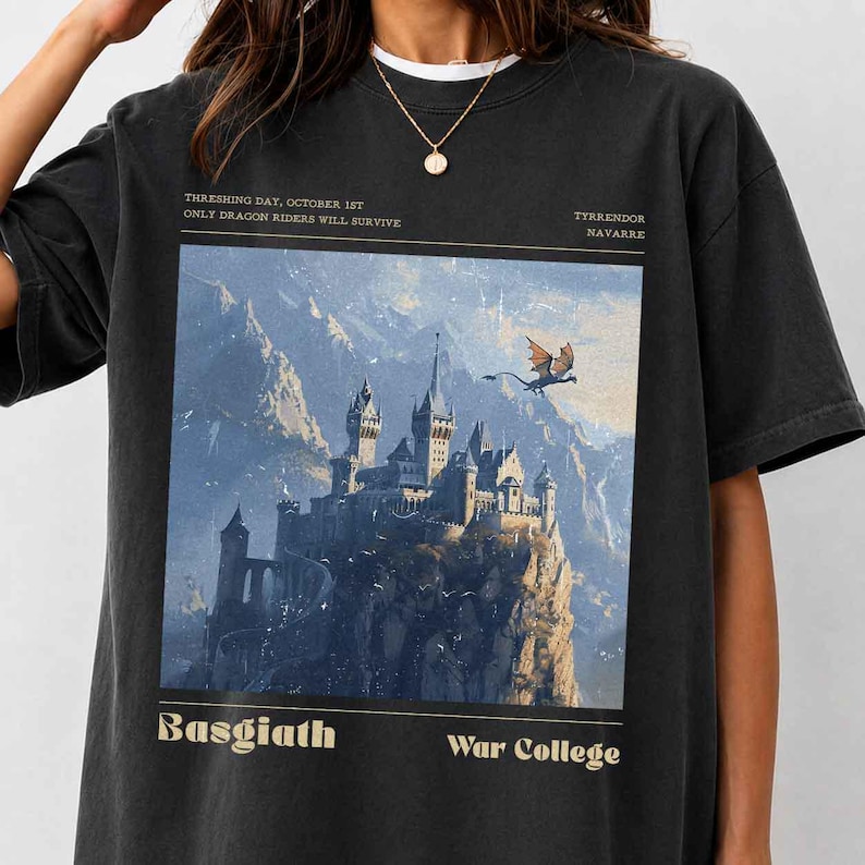 May include: Black t-shirt featuring a fantasy castle illustration with a dragon in flight. The shirt includes text that reads "THRESHING DAY, OCTOBER 1ST ONLY DRAGON RIDERS WILL SURVIVE" and "Basgiath War College".