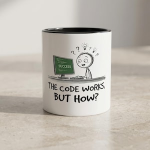 May include: White ceramic mug with a black interior featuring a cartoon illustration of a person at a computer with the text "The code works, but how?" and the word "Success" on the screen.
